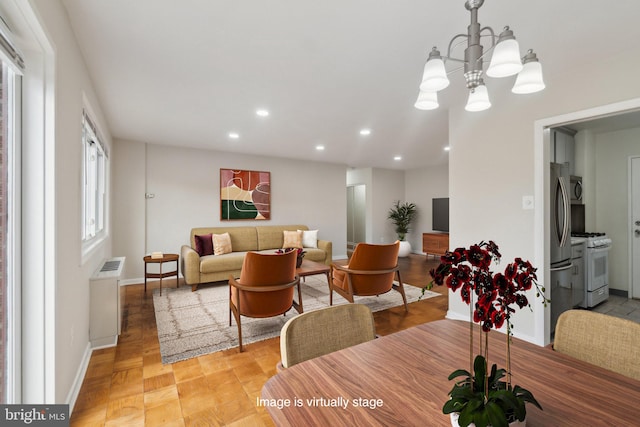 dining room with a chandelier, radiator heating unit, and light wood-type flooring