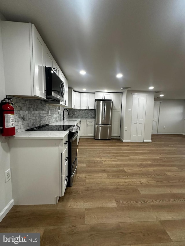 kitchen featuring light hardwood / wood-style floors, white cabinetry, stainless steel appliances, and sink