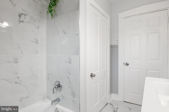 bathroom featuring tiled shower / bath and vanity