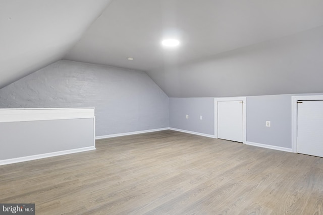 additional living space featuring light hardwood / wood-style flooring and lofted ceiling