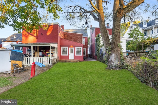 rear view of property with a lawn