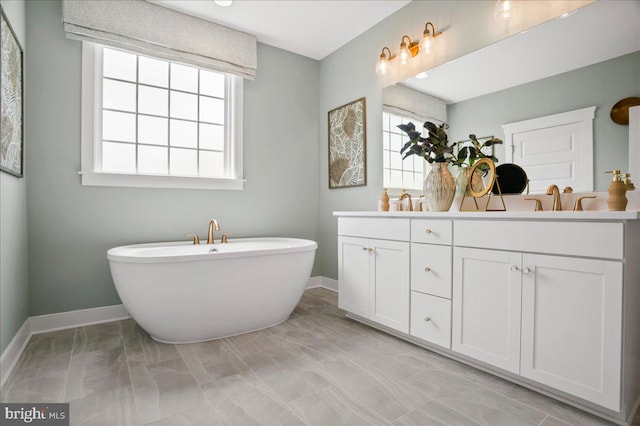 bathroom featuring a tub to relax in and vanity