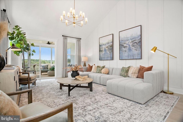 living room with high vaulted ceiling, hardwood / wood-style floors, and an inviting chandelier