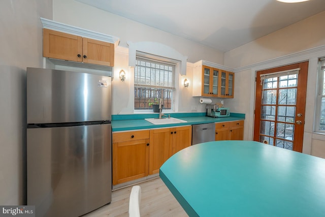 kitchen with appliances with stainless steel finishes, light hardwood / wood-style flooring, sink, and a wealth of natural light