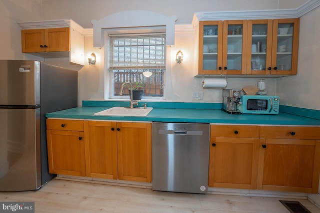 kitchen with sink, stainless steel appliances, and light wood-type flooring