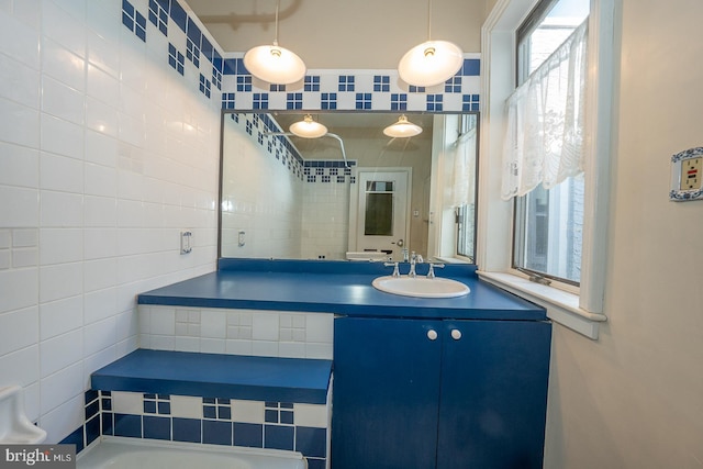 bathroom featuring vanity, tasteful backsplash, and tile walls