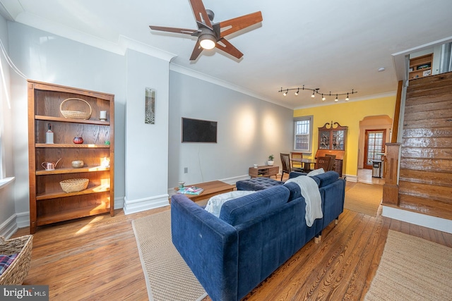 living room featuring crown molding, wood-type flooring, and ceiling fan