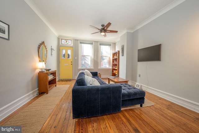 living room featuring light hardwood / wood-style flooring, ornamental molding, and ceiling fan