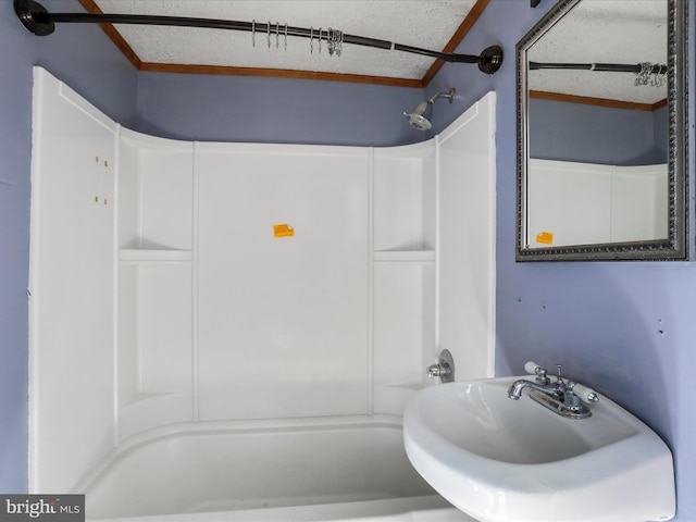 bathroom with sink, crown molding, a textured ceiling, and shower / bath combination