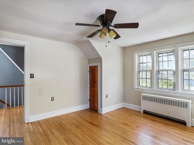 interior space with light hardwood / wood-style flooring, radiator heating unit, and ceiling fan