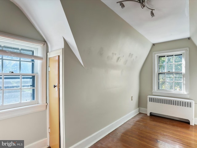 bonus room with hardwood / wood-style flooring, radiator, and vaulted ceiling