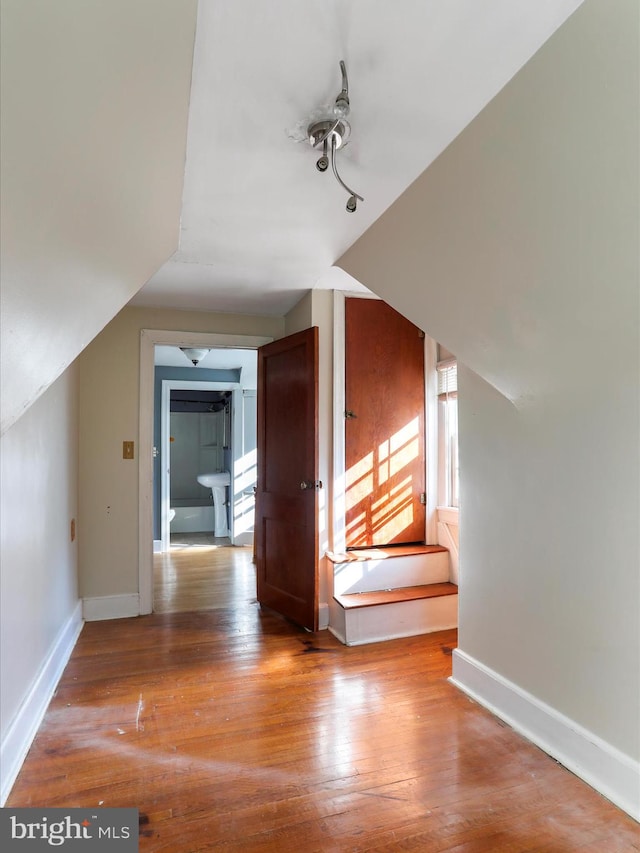 bonus room with vaulted ceiling and wood-type flooring