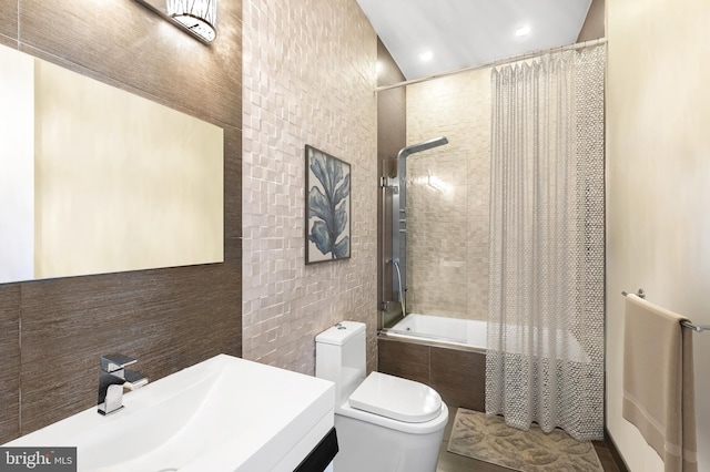 full bathroom with shower / tub combo with curtain, tile walls, vanity, and toilet