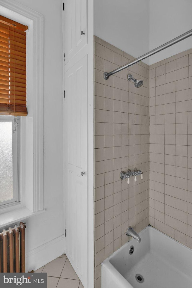 bathroom featuring radiator heating unit, tiled shower / bath combo, and tile patterned floors