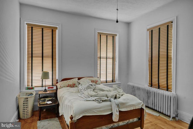 161 W High St, Womelsdorf, PA 19567 - bedroom featuring radiator heating unit, multiple windows, a textured ceiling, and light wood finished floors