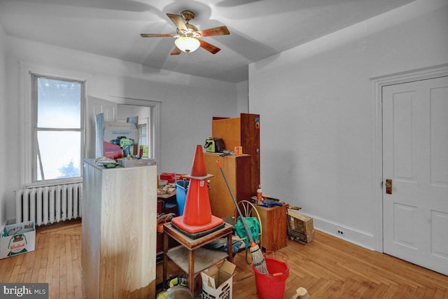 miscellaneous room with radiator heating unit, hardwood / wood-style flooring, and ceiling fan