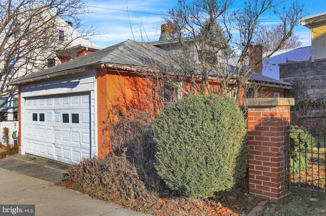 161 W High St, Womelsdorf, PA 19567 - view of home's exterior with a detached garage, a chimney, and brick siding