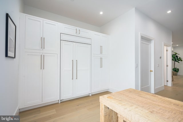 interior space with white cabinets and light wood-type flooring