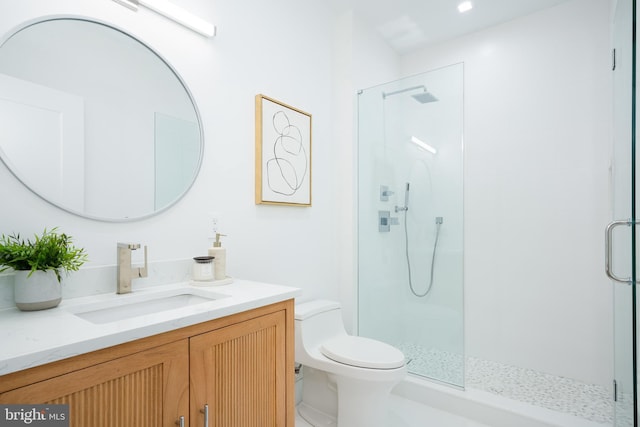 bathroom featuring walk in shower, vanity, and toilet