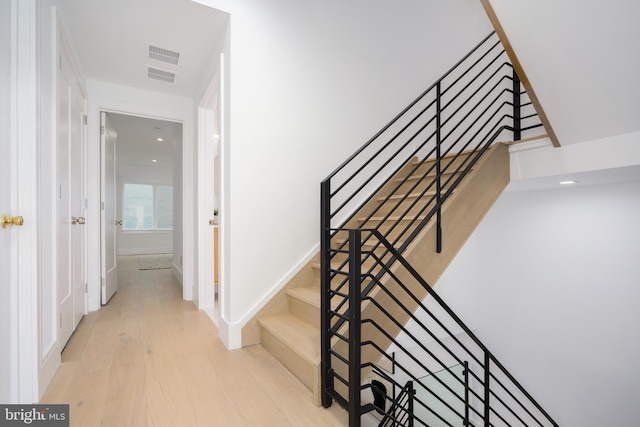 staircase with hardwood / wood-style floors