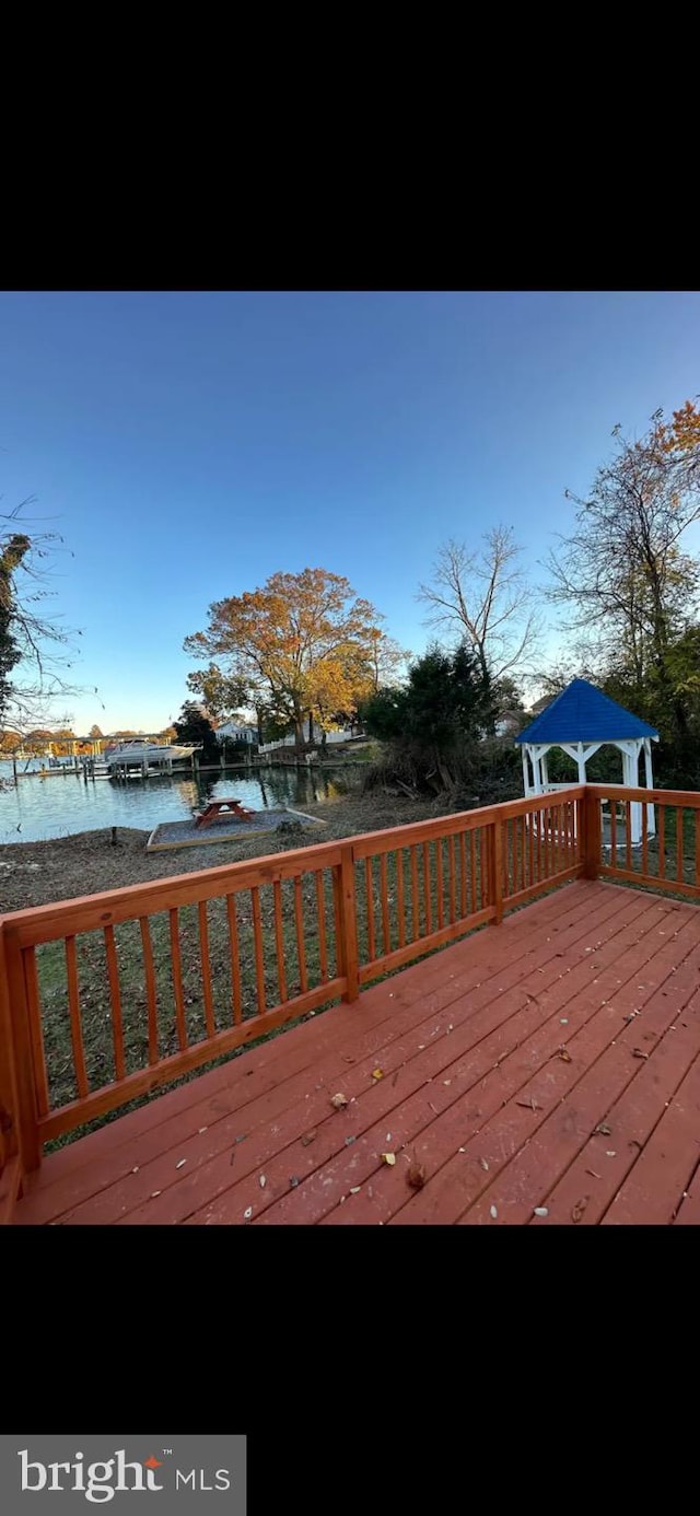 wooden terrace featuring a water view