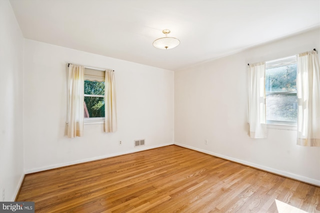 empty room with light hardwood / wood-style flooring and a healthy amount of sunlight