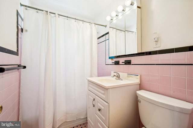 bathroom featuring walk in shower, vanity, tile walls, and toilet