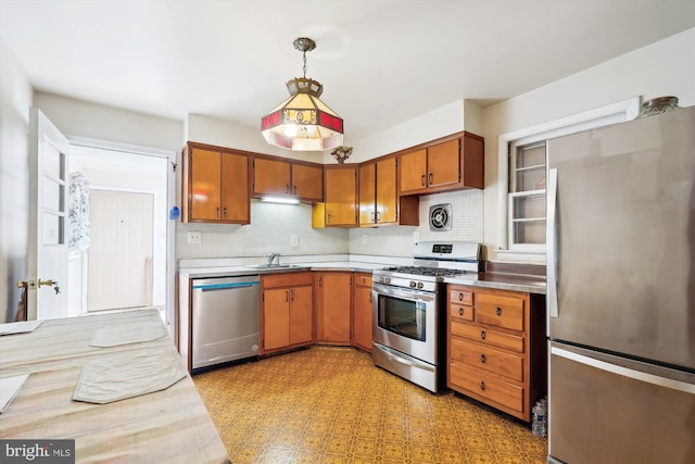 kitchen featuring decorative light fixtures, sink, stainless steel appliances, and backsplash