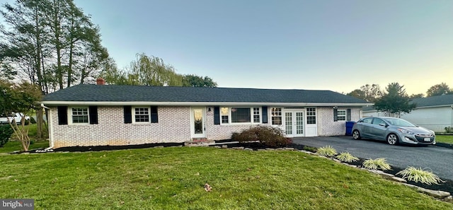 ranch-style house with french doors and a yard