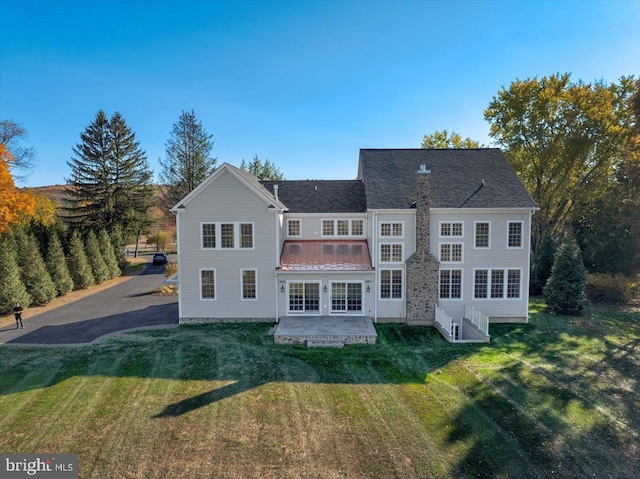 rear view of property with a lawn and a patio area