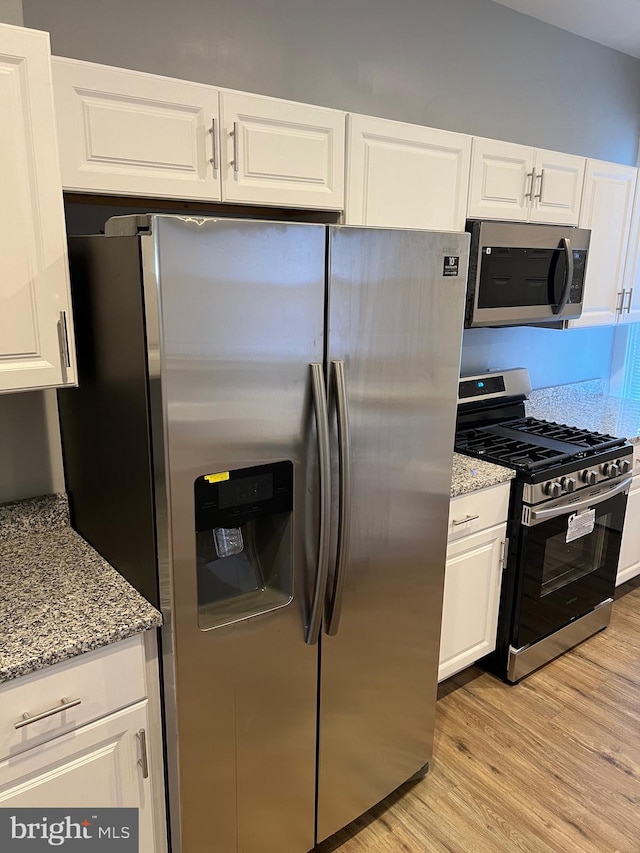 kitchen featuring light hardwood / wood-style floors, white cabinetry, and stainless steel appliances