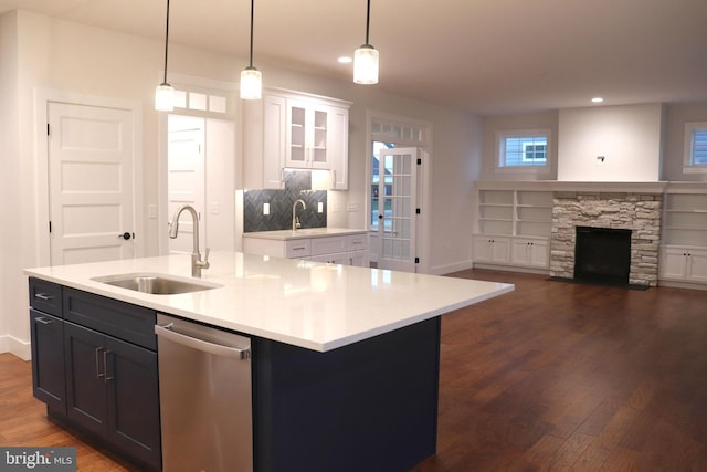 kitchen with white cabinets, pendant lighting, sink, and an island with sink