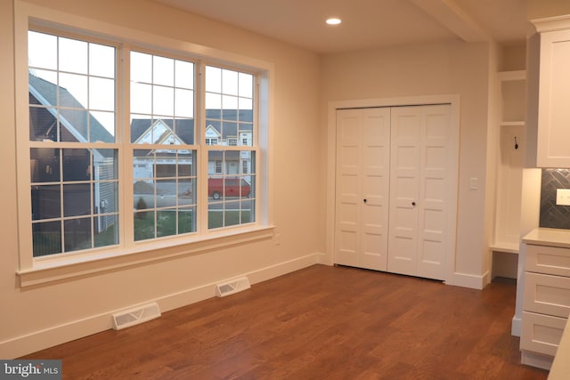 unfurnished bedroom with a closet and dark hardwood / wood-style floors