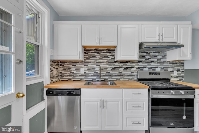 kitchen with white cabinets, backsplash, appliances with stainless steel finishes, wooden counters, and sink