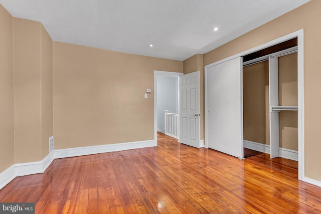 unfurnished bedroom with a closet and hardwood / wood-style floors