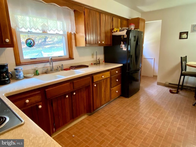 kitchen featuring decorative backsplash, black appliances, and sink