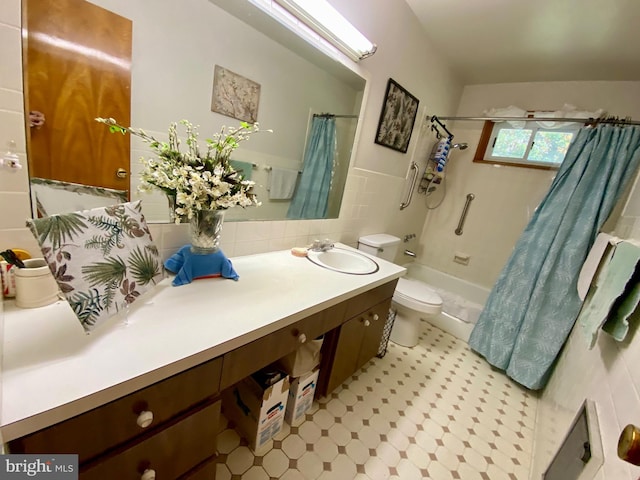 full bathroom featuring toilet, vanity, tile walls, and shower / tub combo