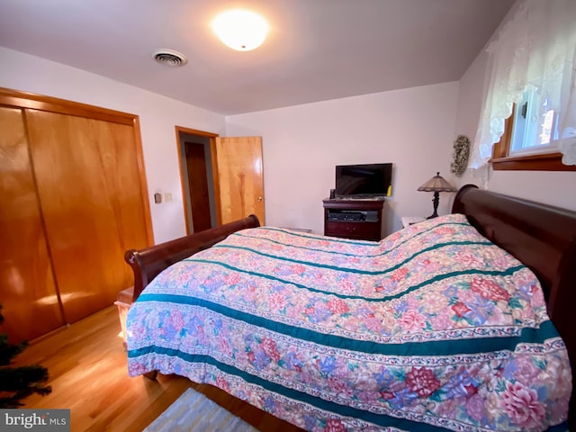 bedroom with a closet and hardwood / wood-style flooring