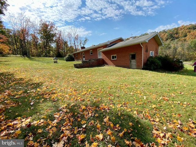 view of side of home with a yard