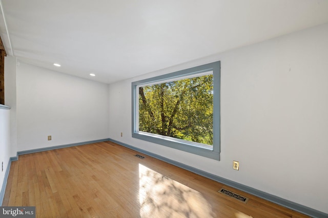 spare room with visible vents, wood finished floors, and baseboards