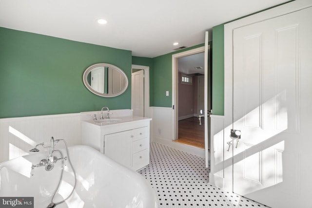 full bathroom with vanity, visible vents, recessed lighting, wainscoting, and a freestanding tub