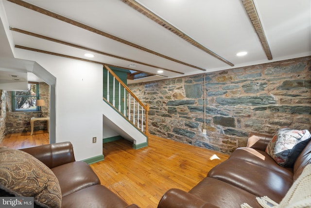 living room with beam ceiling, stairway, wood finished floors, and baseboards