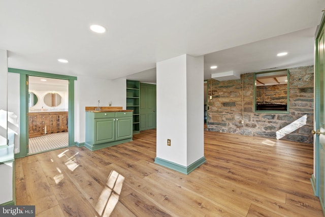 unfurnished living room with recessed lighting, baseboards, and light wood-style floors