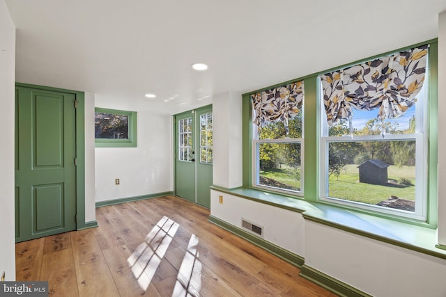 interior space featuring light wood finished floors, baseboards, visible vents, and recessed lighting