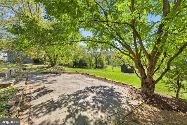view of patio / terrace with an outdoor structure and a storage shed