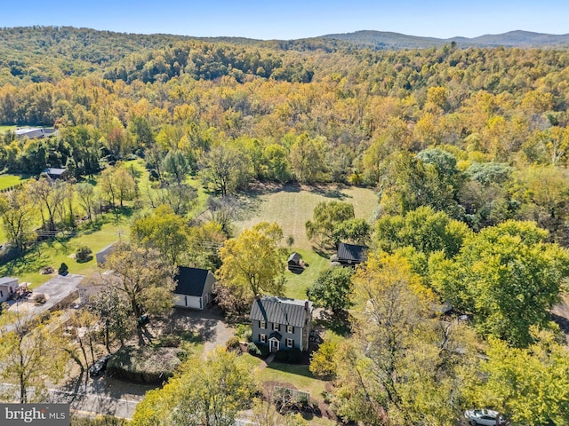 birds eye view of property featuring a mountain view and a wooded view