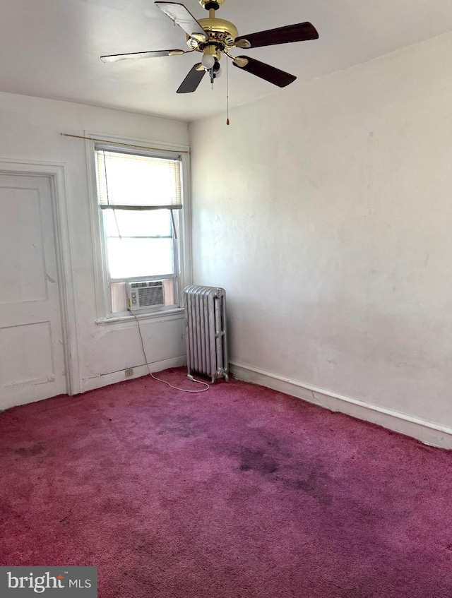 carpeted spare room with ceiling fan and radiator