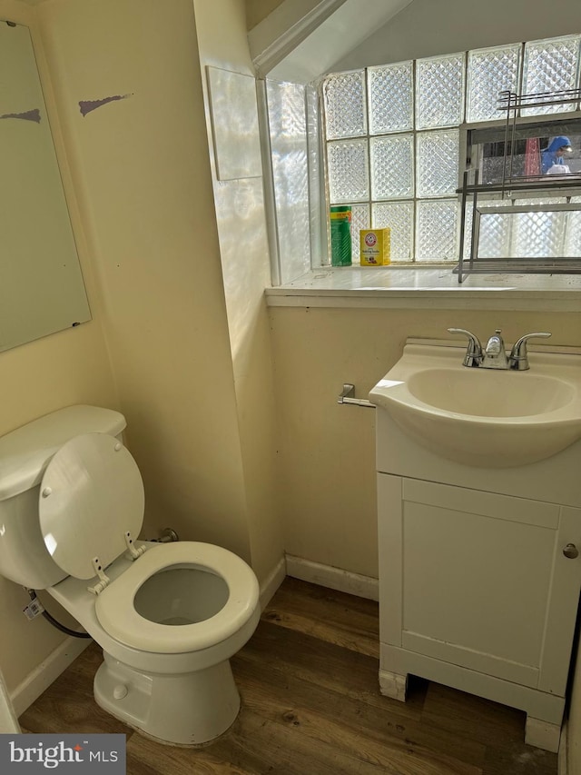 bathroom featuring vaulted ceiling, toilet, vanity, and wood-type flooring