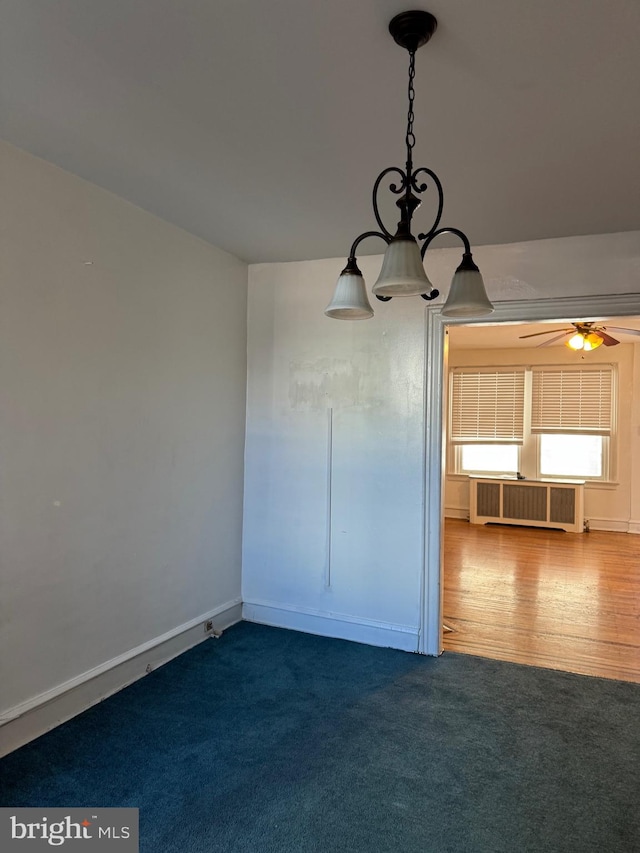 unfurnished dining area with ceiling fan, hardwood / wood-style floors, and radiator heating unit