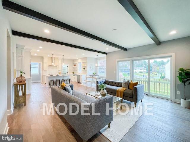 living area with recessed lighting, light wood finished floors, baseboards, and beamed ceiling